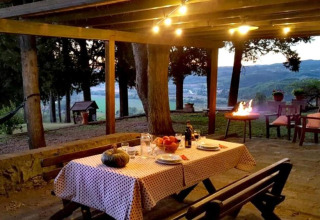 Buiten eetruimte bij Agricampeggio La Prugnola in Toscane, Italië met gezellige verlichting en barbecue.