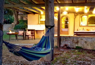 Buitenhoek van Agricampeggio La Prugnola in Toscane met hangmat en gezellig verlichte veranda.
