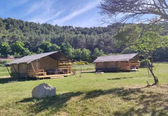 Tentes safari avec salle de bain privée à Agricampeggio La Prugnola en Italie, entourées par la nature.