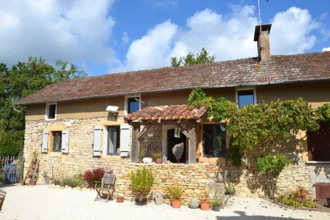 Charmerende stenhytte omgivet af planter og blå himmel nær Montcléra i Occitanie, Frankrig.