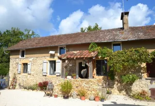 Charmerende stenhytte omgivet af planter og blå himmel nær Montcléra i Occitanie, Frankrig.