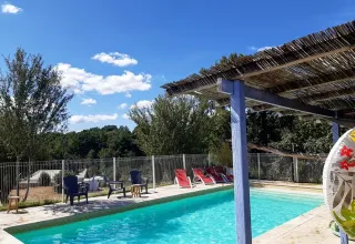 Buitenzwembad met ligstoelen en terras bij Domaine de La Velle, vakantiepark in Occitanië, Frankrijk.