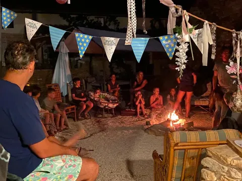 Mensen rond een kampvuur bij Domaine de La Velle vakantiepark in Occitanië, Frankrijk.