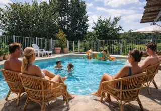 Familien entspannen am Pool des Domaine de La Velle Ferienparks in Occitanie, Frankreich bei Sonnenschein.