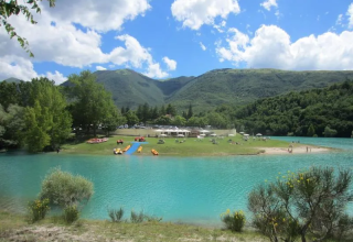 Ein klarer, blauer See mit Bergen im Hintergrund nahe Montelparo in der Region Marken, Italien.