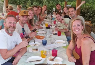 Gruppe mennesker nyder et måltid udendørs under en overdækket terrasse med lys i Marche, Italien.
