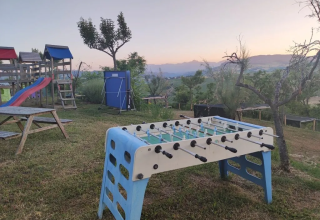Vue sur un baby-foot et une aire de jeux sur l'herbe à Agricampeggio Tasteria, parc de vacances dans les Marches, Italie.