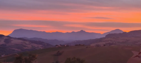 Zonsondergang boven heuvels en bergen bij Agricampeggio Tasteria, Marche, Italië, met kleurrijke lucht.