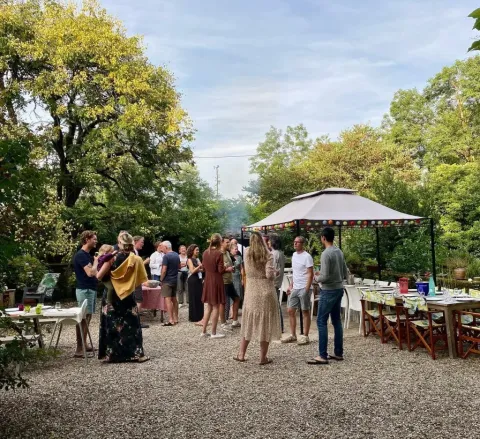 Sommerliche Gartenparty im Les Savonniers Ferienpark, Occitanie, Frankreich mit Gästen und Pavillon.