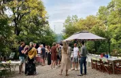 Sommerliche Gartenparty im Les Savonniers Ferienpark, Occitanie, Frankreich mit Gästen und Pavillon.
