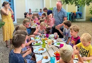 Kinderen en volwassenen aan één tafel bij Les Savonniers vakantiepark in Occitanië, Frankrijk.