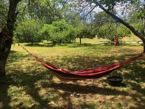 Hängematte zwischen zwei Bäumen im Ferienpark Les Savonniers in Occitanie, Frankreich, an einem sonnigen Tag.