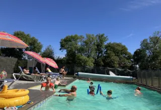 Feriepark Les Savonniers i Occitanie, Frankrig, med børn og voksne, der nyder en udendørs swimmingpool.