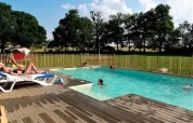 Gäste entspannen am Pool im Ferienpark Les Savonniers, umgeben von Natur in Occitanie, Frankreich.