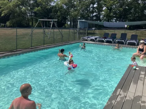 Des familles profitent de la piscine du parc de vacances Les Savonniers en Occitanie, France, par une journée ensoleillée.
