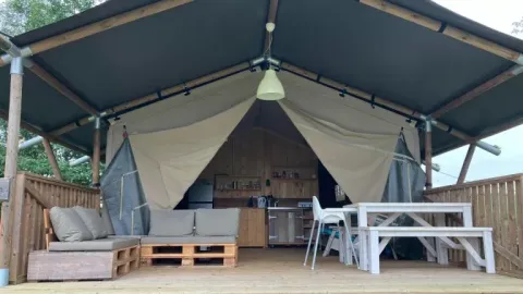 Safaritent bij Les Savonniers in Frankrijk met zicht op het open interieur en houten terras.
