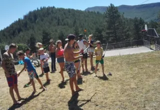 Kinderen en volwassenen spelen buiten bij Domaine Les 2 Soleils in Provence-Alpes-Côte d’Azur, Frankrijk, omgeven door bergen.