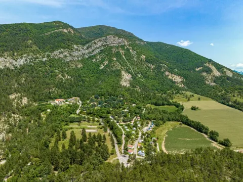 Luchtfoto van Domaine Les 2 Soleils vakantiepark, omgeven door bergen en bossen in Provence-Alpes-Côte d’Azur, Frankrijk.