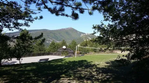 Vakantiepark in Provence-Alpes-Côte d’Azur met sportvelden, bankjes en uitzicht op de bergen.