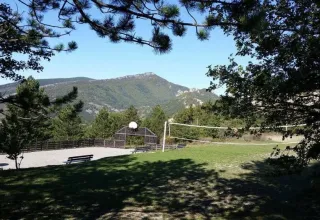 Vakantiepark in Provence-Alpes-Côte d’Azur met sportvelden, bankjes en uitzicht op de bergen.