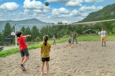 Kinderen en volwassenen spelen volleybal op een zandveld bij Domaine Les 2 Soleils in Provence-Alpes-Côte d’Azur.