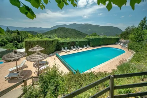 Zwembad met ligstoelen en bergzicht bij Domaine Les 2 Soleils in Provence-Alpes-Côte d’Azur, Frankrijk.