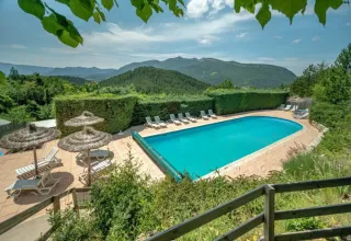 Piscine avec transats et vue sur les montagnes au Domaine Les 2 Soleils, Provence-Alpes-Côte d’Azur, France.