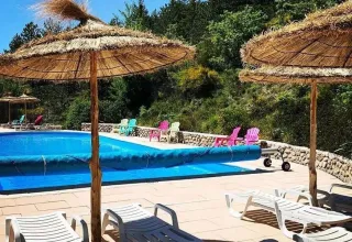 Buitenzwembad met stroparasols en ligstoelen bij Domaine Les 2 Soleils in Provence-Alpes-Côte d’Azur, Frankrijk.