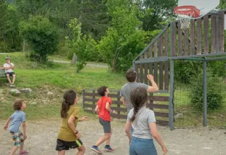 Kinderen en volwassenen spelen basketbal buiten bij Domaine Les 2 Soleils, vakantiepark in Zuid-Frankrijk.