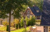 Vista exterior de Wellness Lodge XXL en Hof van Salland, Países Bajos, con jardín y muebles de terraza.