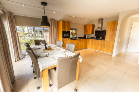 Eethoek en moderne keuken in Wellness Lodge XXL bij Hof van Salland, Nederland, met grote raampartijen.