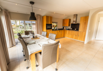 Comedor y cocina moderna en Wellness Lodge XXL en Hof van Salland, Países Bajos, con grandes ventanales.