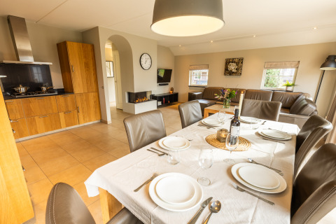 Moderne keuken en eetruimte met gedekte tafel in Wellness Lodge XXL van Hof van Salland, Nederland.