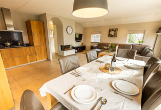 Moderne keuken en eetruimte met gedekte tafel in Wellness Lodge XXL van Hof van Salland, Nederland.