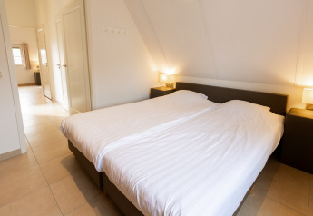 Dormitorio luminoso en Wellness Lodge XXL en Hof van Salland, Países Bajos, con cama doble y decoración moderna.