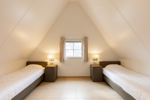 Kamer met twee eenpersoonsbedden, schuin plafond en raam in Wellness Lodge XXL, Hof van Salland, Nederland.