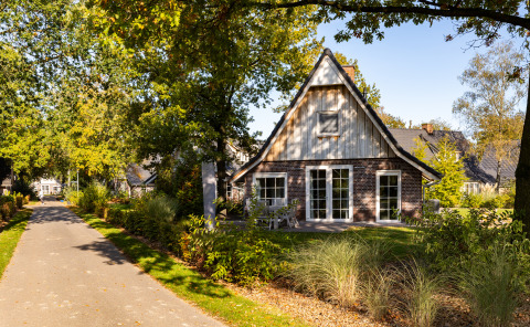 Wellness Lodge XL en Hof van Salland, Países Bajos, rodeada de vegetación y un sendero tranquilo al sol