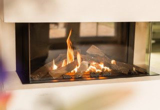 Moderne Kamin mit Flammen in der Wellness Lodge XL im Hof van Salland, Niederlande, gemütliche Atmosphäre.