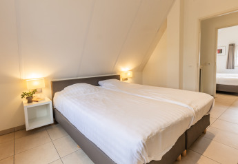 Chambre à la Wellness Lodge XL au Hof van Salland, Pays-Bas, avec lit double et tables de nuit.