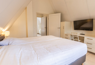 Dormitorio luminoso en Wellness Lodge XL, Hof van Salland, Países Bajos, con cama doble, TV y escritorio.