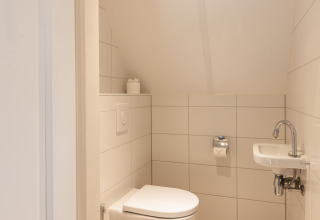 Pequeño baño moderno en Wellness Lodge XL, Hof van Salland, Países Bajos, con inodoro suspendido.