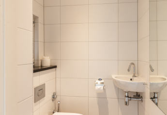 Salle de bains moderne et compacte avec WC mural et lavabo, Wellness Lodge XL, Hof van Salland, Pays-Bas.