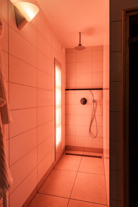 Moderne Dusche mit warmer Beleuchtung in der Wellness Lodge XL im Hof van Salland, Niederlande.