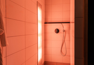 Moderne Dusche mit warmer Beleuchtung in der Wellness Lodge XL im Hof van Salland, Niederlande.