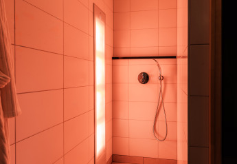 Douche moderne avec éclairage chaleureux dans la Wellness Lodge XL au Hof van Salland, Pays-Bas.