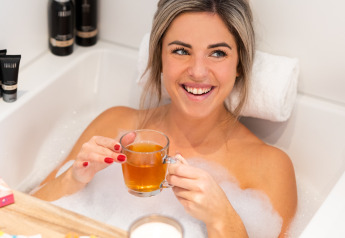 Femme se relaxant avec du thé et des chocolats dans un bain moussant au Wellness Lodge XL, Hof van Salland, Pays-Bas.