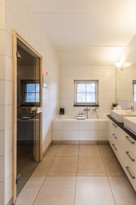 Baño moderno con sauna y bañera en Wellness Lodge XL, Hof van Salland, Países Bajos.
