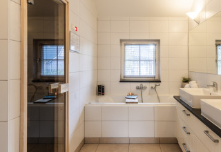 Baño moderno con sauna y bañera en Wellness Lodge XL, Hof van Salland, Países Bajos.