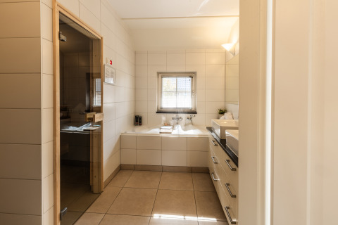 Modernes Badezimmer in der Wellness Lodge XL im Hof van Salland, Niederlande, mit Badewanne und Sauna.