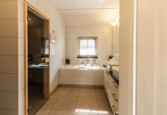 Salle de bain moderne à la Wellness Lodge XL au Hof van Salland, Pays-Bas, avec baignoire et sauna.